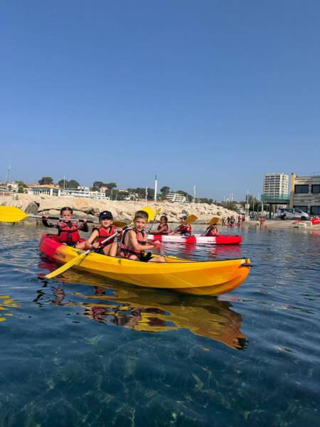 Trois enfants dans un kayak sur l'eau